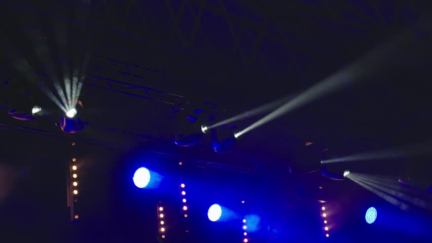 Stage with bright concert lighting, spotlights and smoke effects prepared for live music performance. Illumination for music event