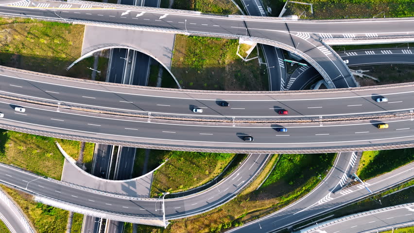 Rising over the complicated road conjunction with cars moving by. Highways, loops and freeways from top view.