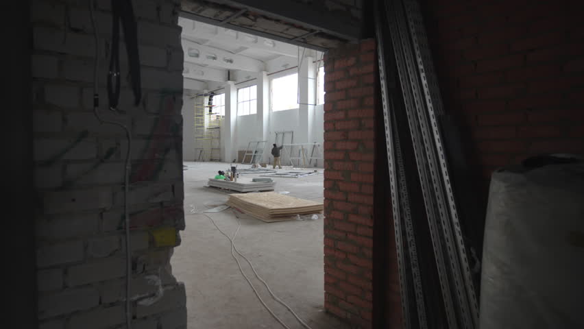 Empty unfinished enclosure with building equipment at renovated factory. Process on modern business center redesigning at construction site