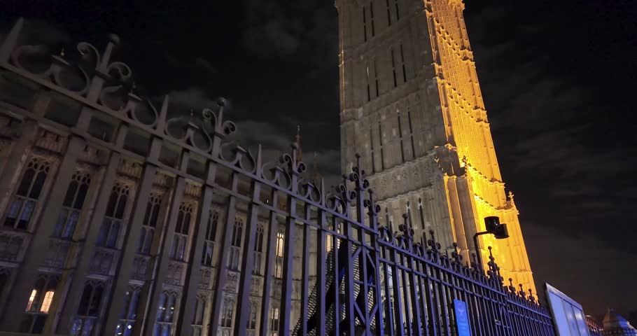 First-person and detail nighttime walking shot crossing Westminster Bridge while contemplating the Clock Tower of the Palace of Westminster in London, United Kingdom