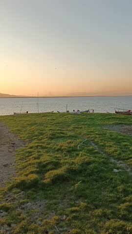 Lake with Boats on Shore at Sunset