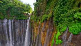 Cinematic FPV drone shot diving through the stunning multi-stream Tumpak Sewu waterfall, surrounded by lush rainforest cliffs in East Java, Indonesia. - Powered by Shutterstock - Get 15% off with code: PIKWIZARD15
