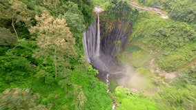Cinematic FPV drone shot diving through the stunning multi-stream Tumpak Sewu waterfall, surrounded by lush rainforest cliffs in East Java, Indonesia. - Powered by Shutterstock - Get 15% off with code: PIKWIZARD15