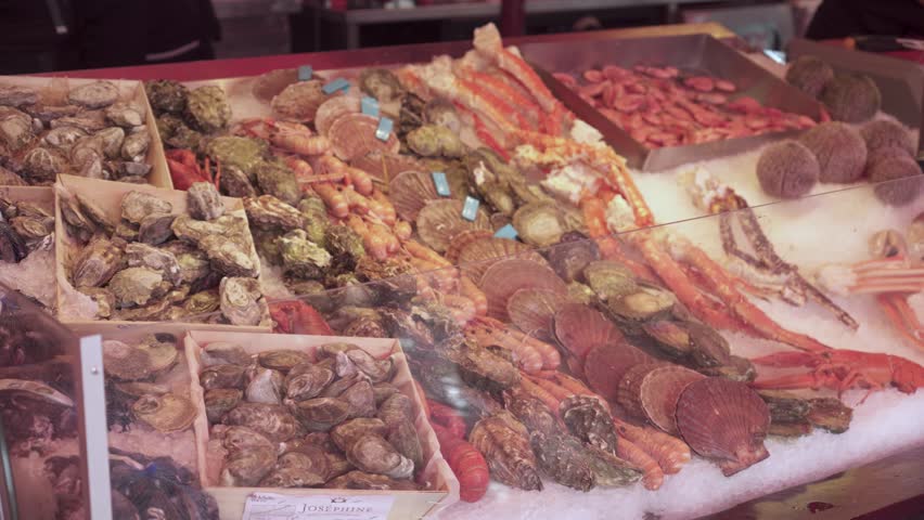Scallops, Oysters, Shrimp, Prawns, Clams, Crab Legs, And Sea Urchins Display At The Fish Market In Bergen, Norway. - closeup shot