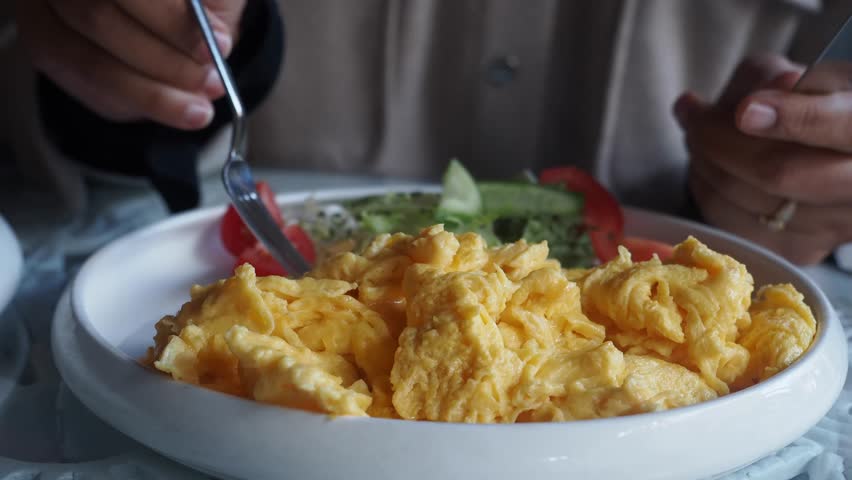 Enjoying a delicious plate of scrambled eggs with fresh salad