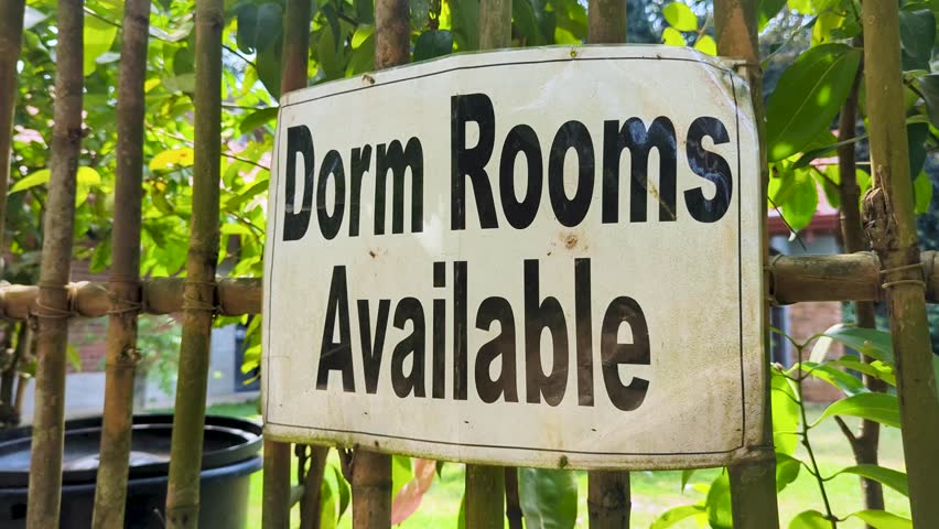 Closeup of sign Dorm Rooms Available at budget friendly hotel and hostel accommodation displayed on fence