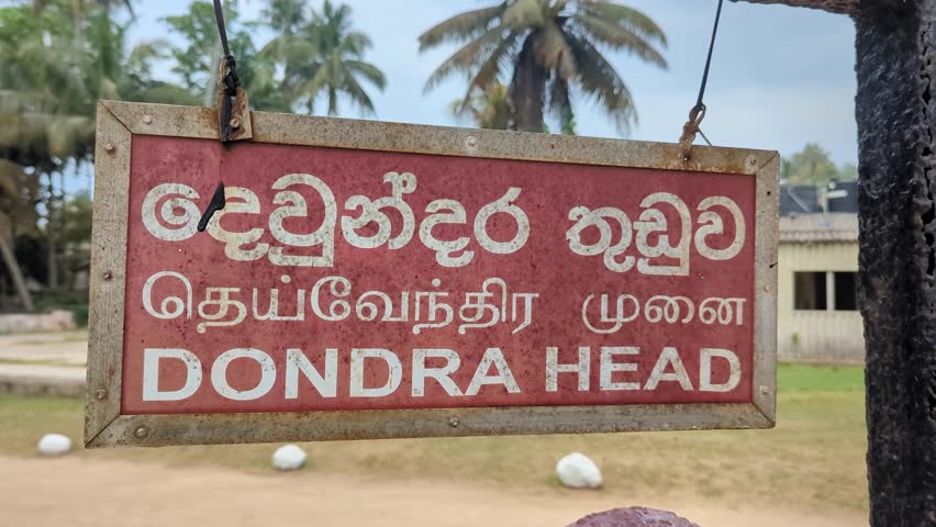 Closeup of Dondra Head Lighthouse sign at southernmost point in English, Tamil, and Sinhala languages