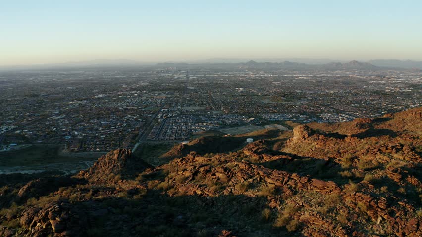 Sprawling neighborhoods in Phoenix, Arizona with mountains in the foreground.