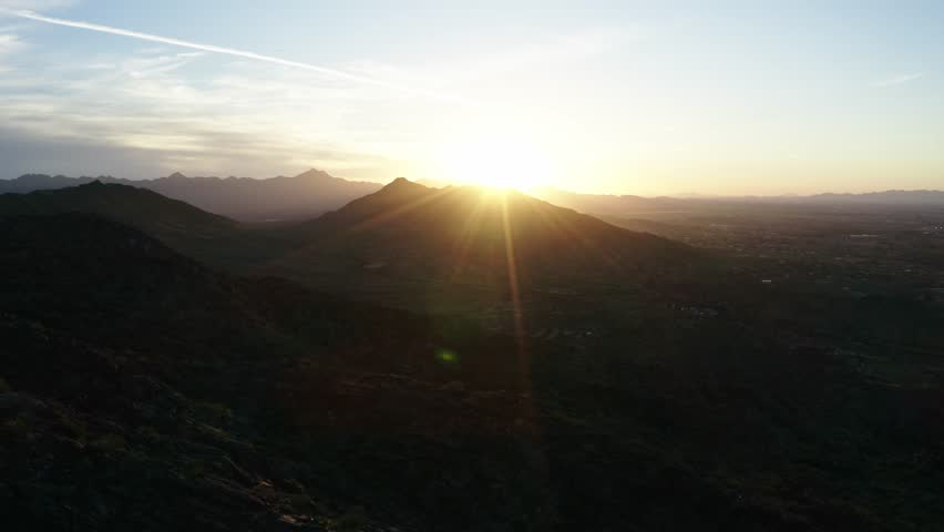 Drone shot of the sun cresting over mountains in Phoenix, Arizona.
