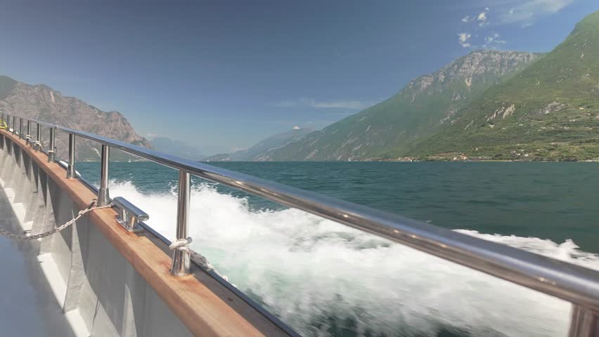 Fast ferry boat crossing lake with mountain views Starboard rail POV