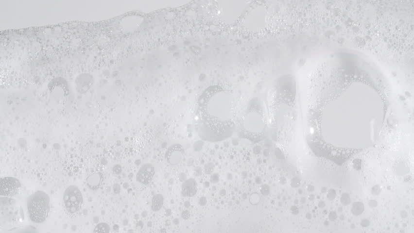 Texture of white soap foam with bubbles abstract background. Soap sud macro structure. Bathtup Soap Foam. Natural White Shampoo Bubbles Motion.