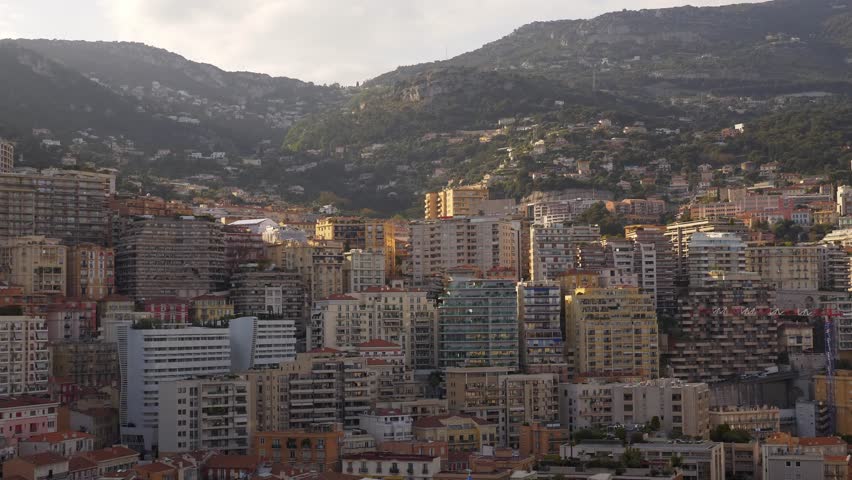 Monaco - 7 May 2019 Panoramic view of densely packed residential and modern buildings in Monaco nestled against lush green hills. 