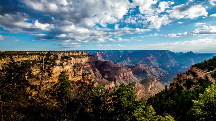 time-lapse AERIAL Grand Canyon, USA with amazing lighting, clouds, red cliffs and blue skies in 4K DCI. View over the sunny a red rock of mountain Zion