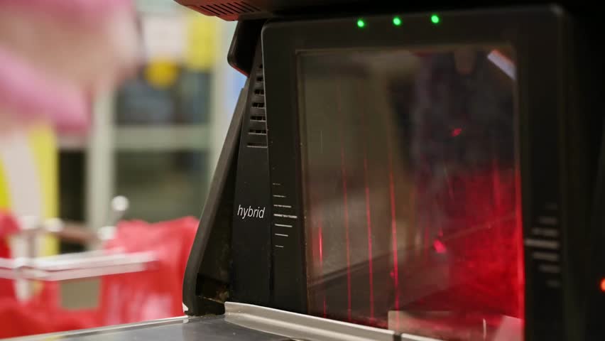 working on grocery store checkout counter. cashier scanning items on modern super market store