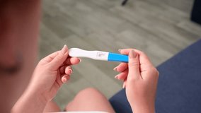 Female hands holding a pregnancy test, in which the result is expected to appear. Camera approaching, close-up. Concept of pregnancy and childbirth. - Powered by Shutterstock - Get 15% off with code: PIKWIZARD15