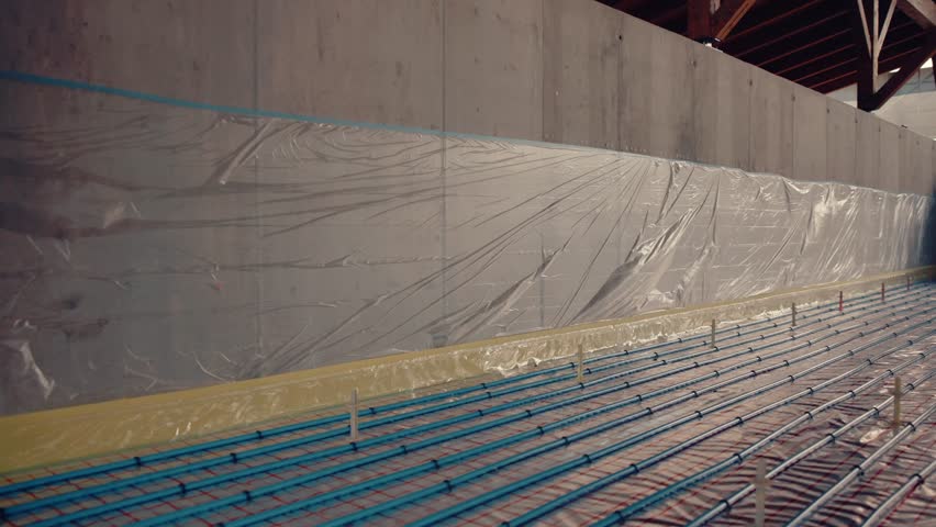 Plastic film covering an underfloor heating system during installation on a construction site