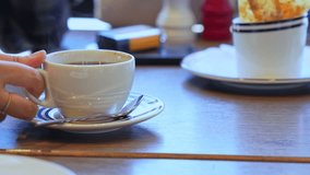 Smooth motion of a hand lifting and placing a steaming coffee cup on a café table, ideal for lifestyle, beverage ads, or relaxation content. - Powered by Shutterstock - Get 15% off with code: PIKWIZARD15