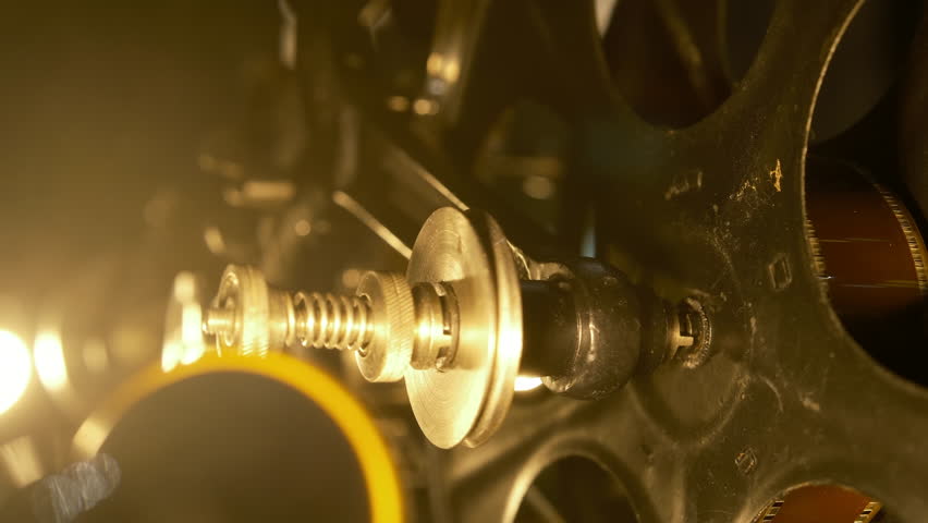 cinematic, vintage movie projector activating a vintage cinematic experience. with a diffused light beam, close-up filmstrip 4k