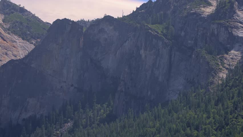 Slow zoom-out view of a massive granite cliff face in Yosemite National Park