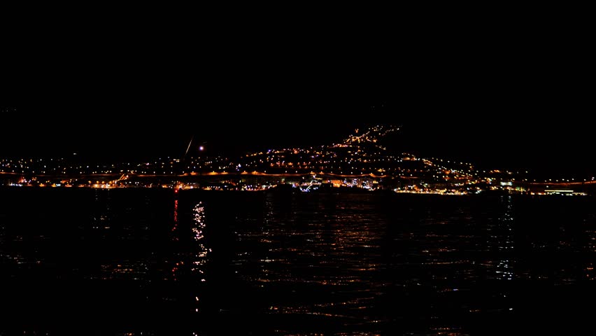 Dark seascape glows faintly as early morning voyage nears Tenerife coast