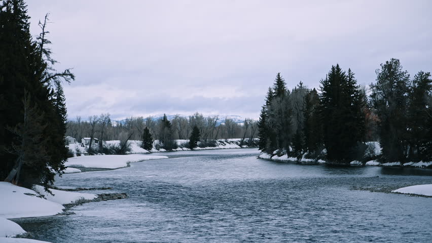 River Flowing Between Snowy Banks