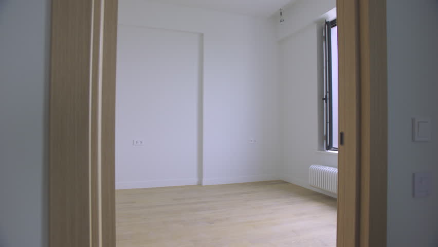 Camera Glides Through Doorway Into Bright Empty Room.
A smooth tracking shot moves through a doorway into a pristine, sunlit empty room. 4K cinematic real estate footage.