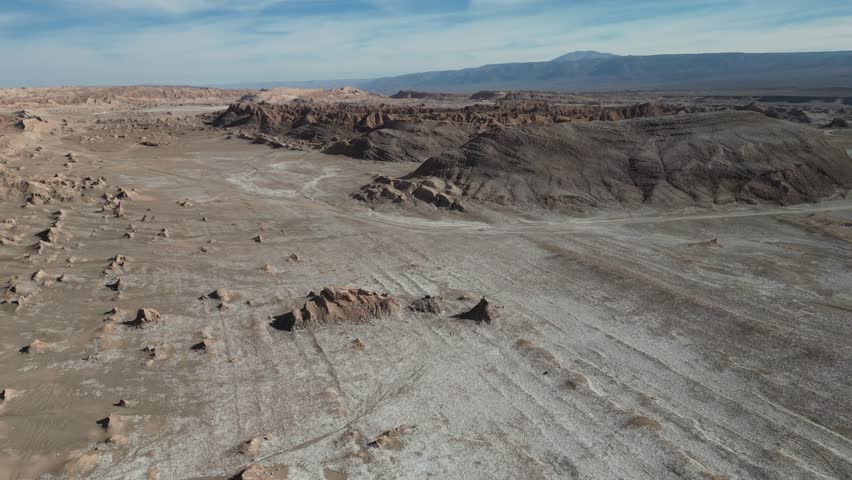 A drone scene of Death Valley in Atacama Desert, Chile, featuring salt flats, and peaks on a sunny day