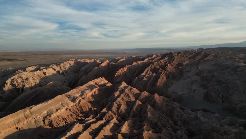 A drone view of the jagged red rock formations and expansive arid landscape in Death Valley in the Atacama Desert in Chile