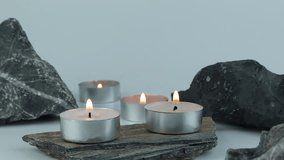 burning natural wax aromatic scented candle on white table with some stones decorating in living room to create relax ambient vibes during Christmas party celebration new year , tealight candles - Powered by Shutterstock - Get 15% off with code: PIKWIZARD15