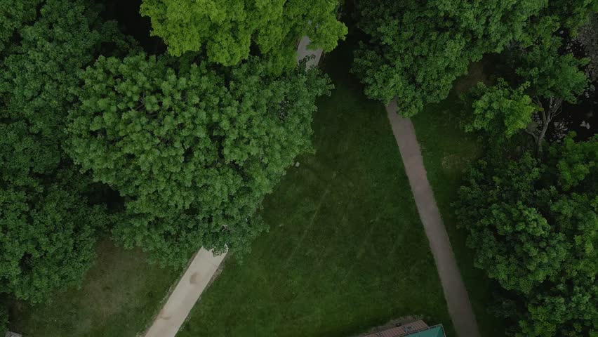 4K drone flyover of a tree-lined pathway and creek at Coronation Park in Grimsby, Ontario.