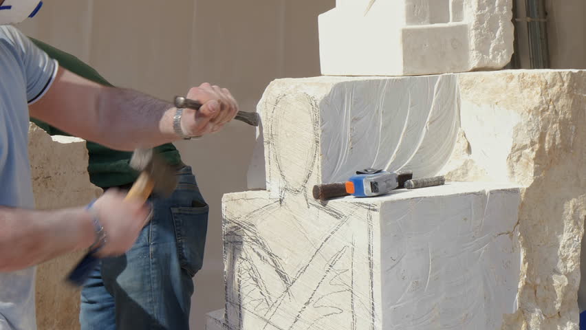 Sculptor's hands working on a white stone block, carving a human figure with chisel and hammer. Captures artistry, craftsmanship, and creation process.