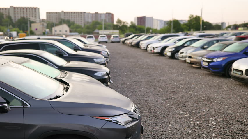 A row of cars parked in an outdoor lot, perfect for a car dealership or automotive advertisement.