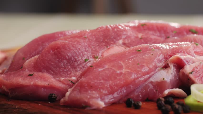 Raw slice beef meat in spices: paprika, salt, pepper, turmeric on plate close-up. Preparing raw food for cooking. Grill and Fry beef, pork, chicken, duck, turkey kebab with vegetables.