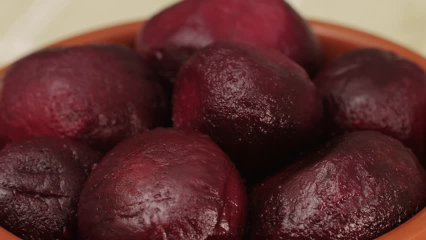 Raw peeled vegetable beet in plate on wooden table close-up. Preparing raw vagetables food for cooking. Cooking traditional Russian Borsch. 
