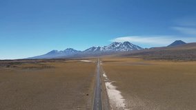 An aerial view of an unbroken desert road leading to the mountainous horizon in northern Chile - Powered by Shutterstock - Get 15% off with code: PIKWIZARD15