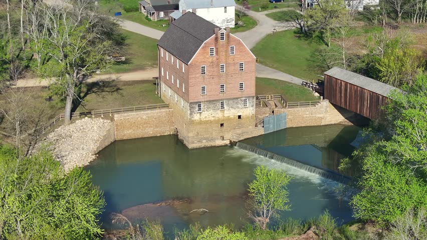 Aerial view of the mill with the wooden covered bridge spanning across the water, a picturesque scene of rustic architecture, Burfordville, Missouri, United States.