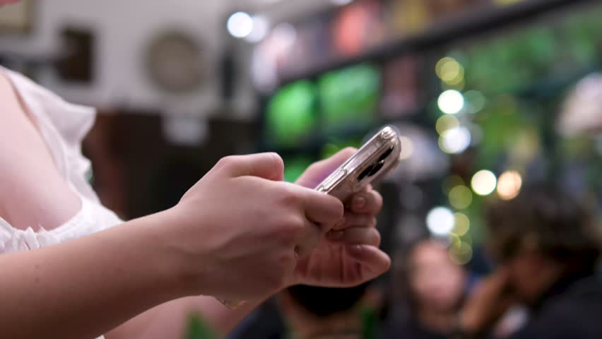Rack focus shot of smiling teenage girl listening music while using mobile phone at home