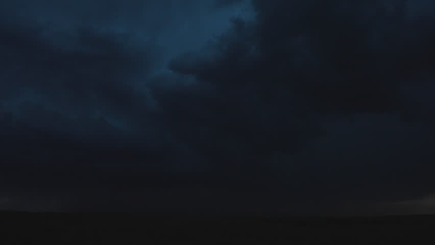 Massive lightning bolts streak across the sky, illuminating the horizon on a stormy night and creating a breathtaking display of nature’s raw and electrifying power