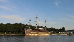 Classic wooden ship with three masts anchored by the riverside. Maritime atmosphere blends with green surroundings and soft sunlight. Nautical nostalgia on a quiet scenic afternoon - Powered by Shutterstock - Get 15% off with code: PIKWIZARD15