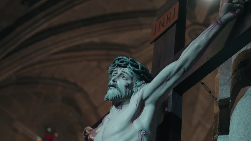 wounded jesus gazes upward from the crucifix in solemn church silence
