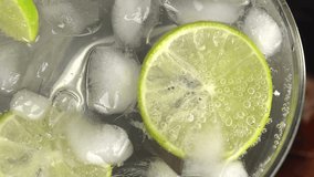 Close-up of lime slices in a glass with ice. A close-up of a refreshing beverage shows fizzy bubbles rising around ice cubes and fresh lime slices in a glass, evoking summer and coolness. Macro shot. - Powered by Shutterstock - Get 15% off with code: PIKWIZARD15