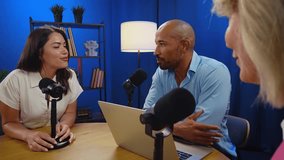 Professional podcasters recording interview within dedicated studio, speaking into microphones against vibrant red background, sharing engaging insights during multimedia content creation process - Powered by Shutterstock - Get 15% off with code: PIKWIZARD15