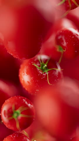 Animation of a group of tomato. Many tomatoes slowly rotate in the background in space. Vertical composition. Defocus. Close-up.
