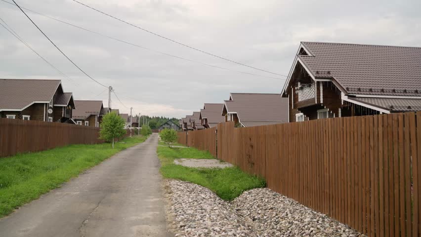 Wooden cottage village street view under cloudy sky