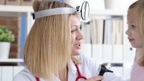 Woman doctor examines young schoolgirl ear using otoscope device. Pediatric checkup requires gentle care building trust through calm interaction - Powered by Shutterstock - Get 15% off with code: PIKWIZARD15