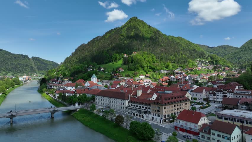 Aerial views of Slovenian landscapes in spring. Aerial panorama of Lasko town nestled among green hills. Famous for thermal spas, brewery, and peaceful natural surroundings in spring sunshine.