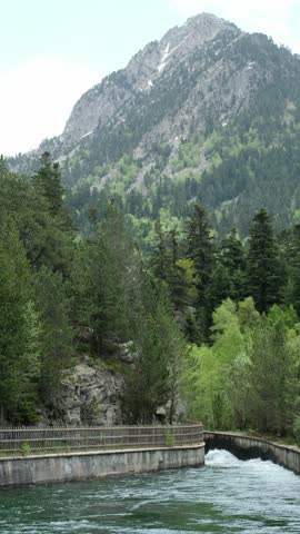 Turbulent Mountain River Flowing between Man-made Concrete Banks. Aigüestortes i Estany de Sant Maurici National Park. Catalan Pyrenees, Spain.