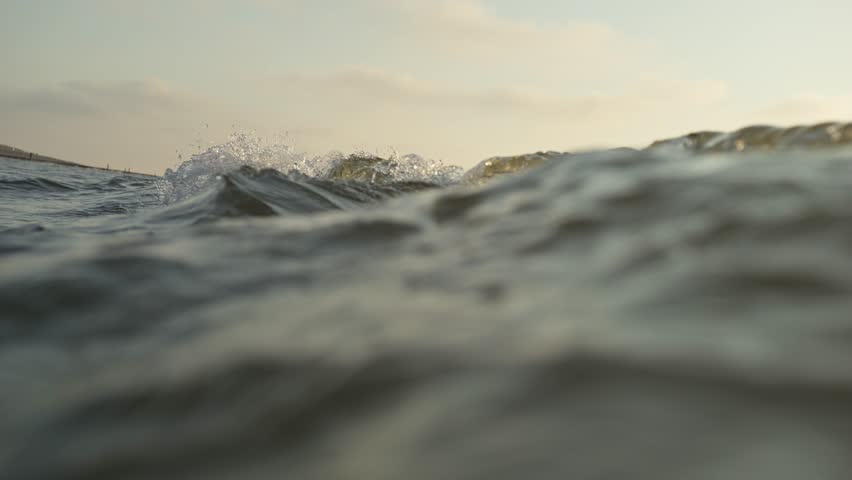 Slow motion close-up of a small wave approaching the beach. Shot in Domburg, the Netherlands.