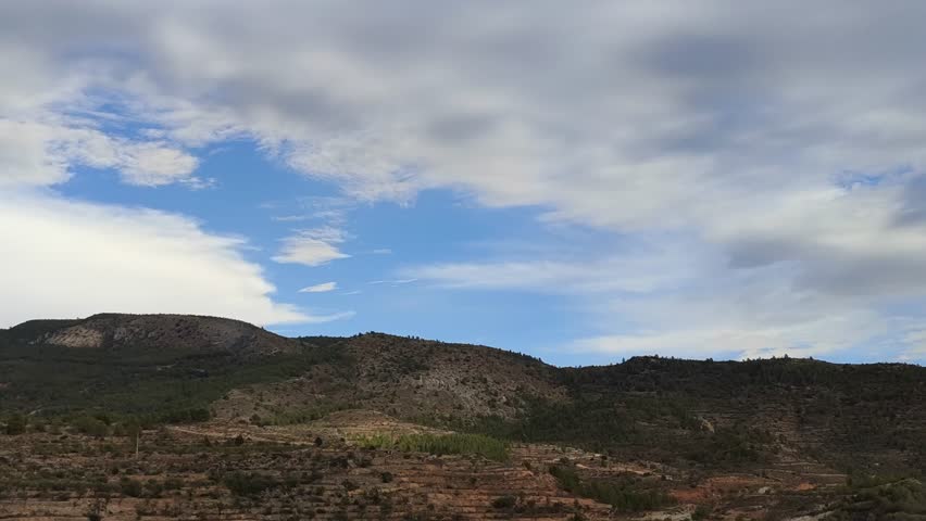 Timelapse of changing clouds, light, and weather over mountainous landscape