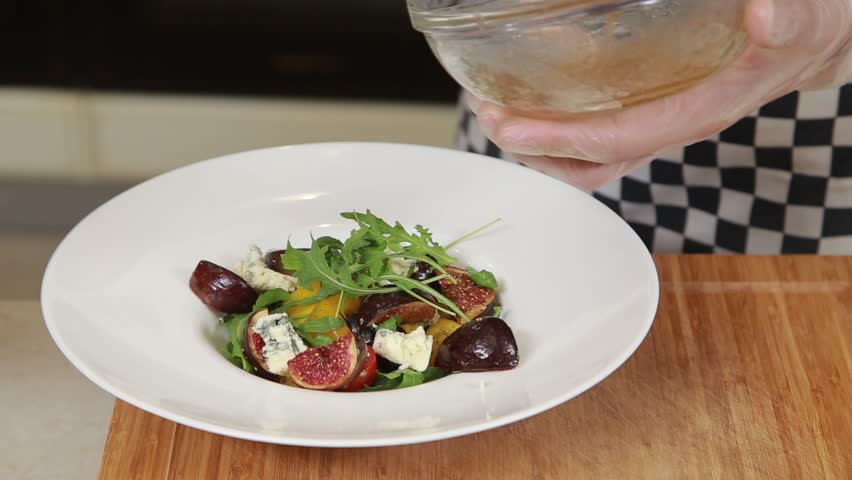 Chef is serving warm salad with figs and blue cheese